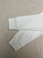 White long-sleeve shirt laid flat showing sleeves and straight hem