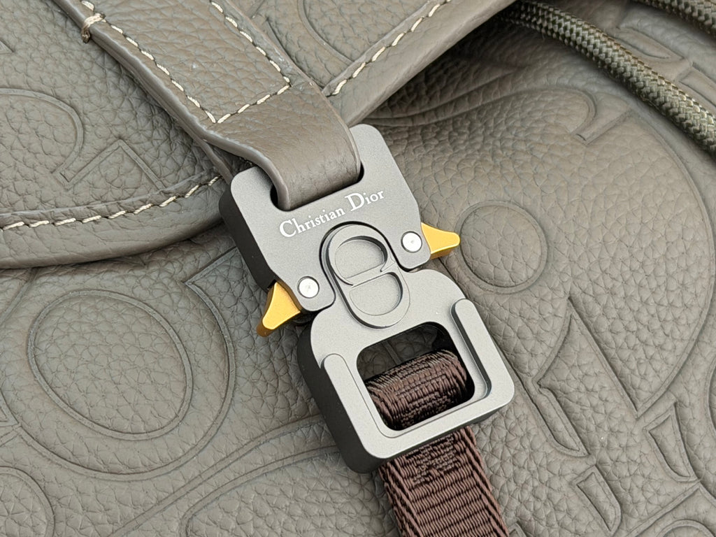 Gray Dior bag strap clip with “Christian Dior” label and metal clasp.