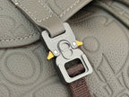 Gray Dior bag strap clip with “Christian Dior” label and metal clasp.