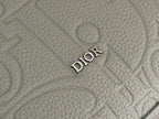 Light gray embossed Dior lettering on textured leather bag panel