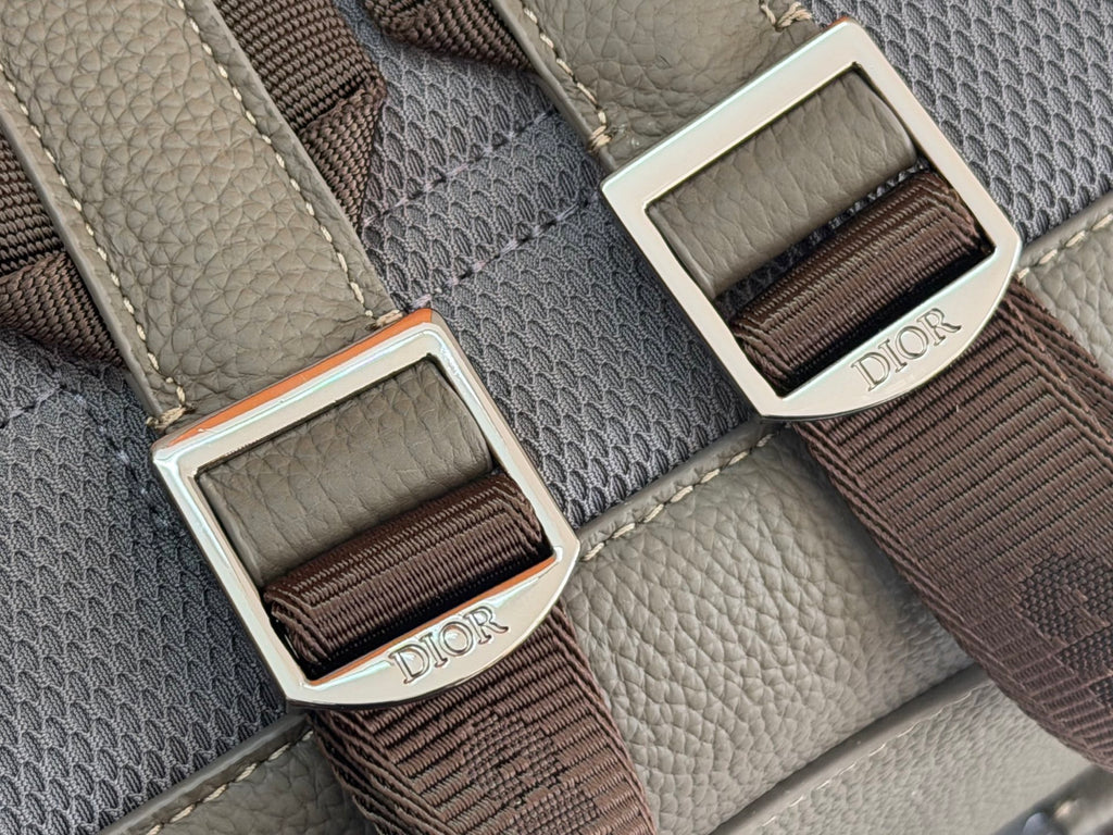 Gray bag with webbing strap and metal buckles featuring Dior labels