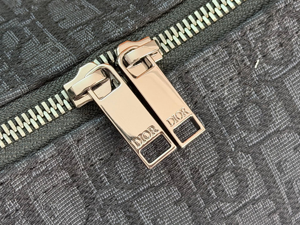 Dior men’s bag zipper with gold-tone double pull and “DIOR” labels