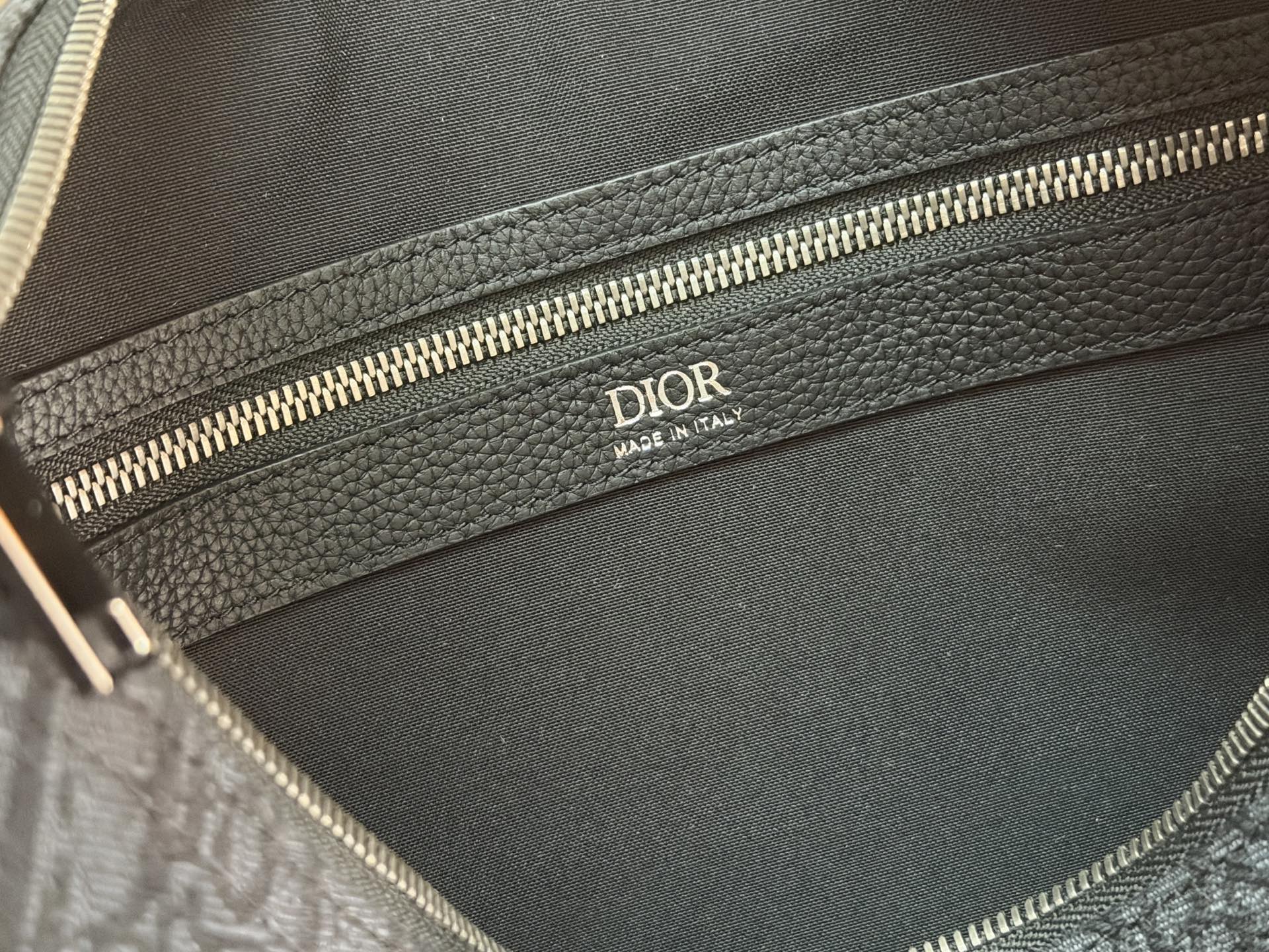 Dior men’s bag interior lining with gold “DIOR” label near zipper