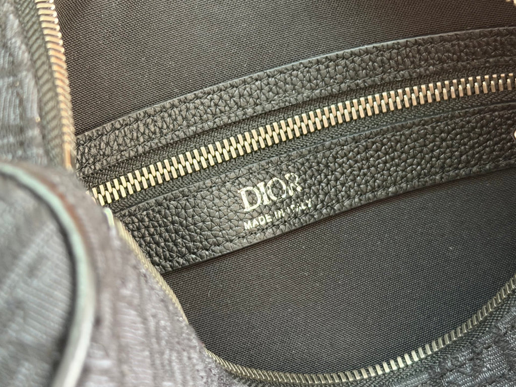 Dior logo on interior lining with gold-tone zipper detail on gray bag