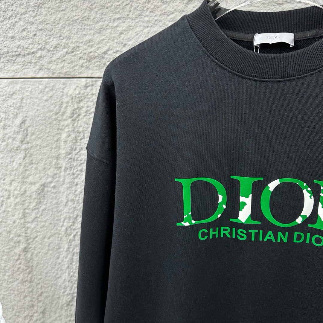 Black sweatshirt close-up with green DIOR and CHRISTIAN DIOR print