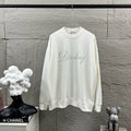 White long-sleeve sweatshirt with crew neck and glitter script logo on chest.