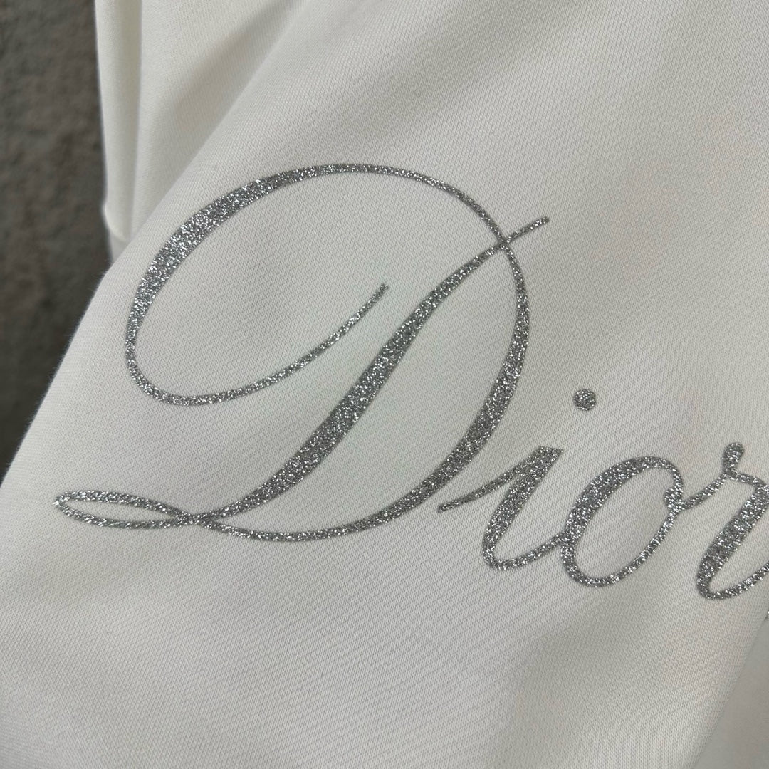 White sweatshirt close-up of large glitter “Diorling” script logo.