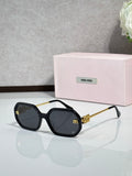 MiuMiu black sunglasses with gold-tone arms and dark tinted lenses