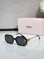 MiuMiu black sunglasses with gold-tone arms and dark tinted lenses