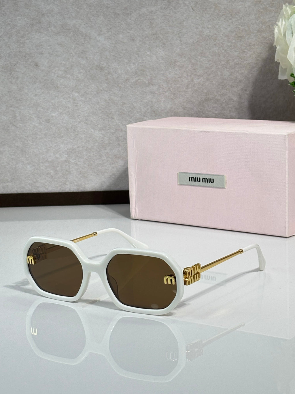 MiuMiu white sunglasses with gold-tone arms and dark tinted lenses