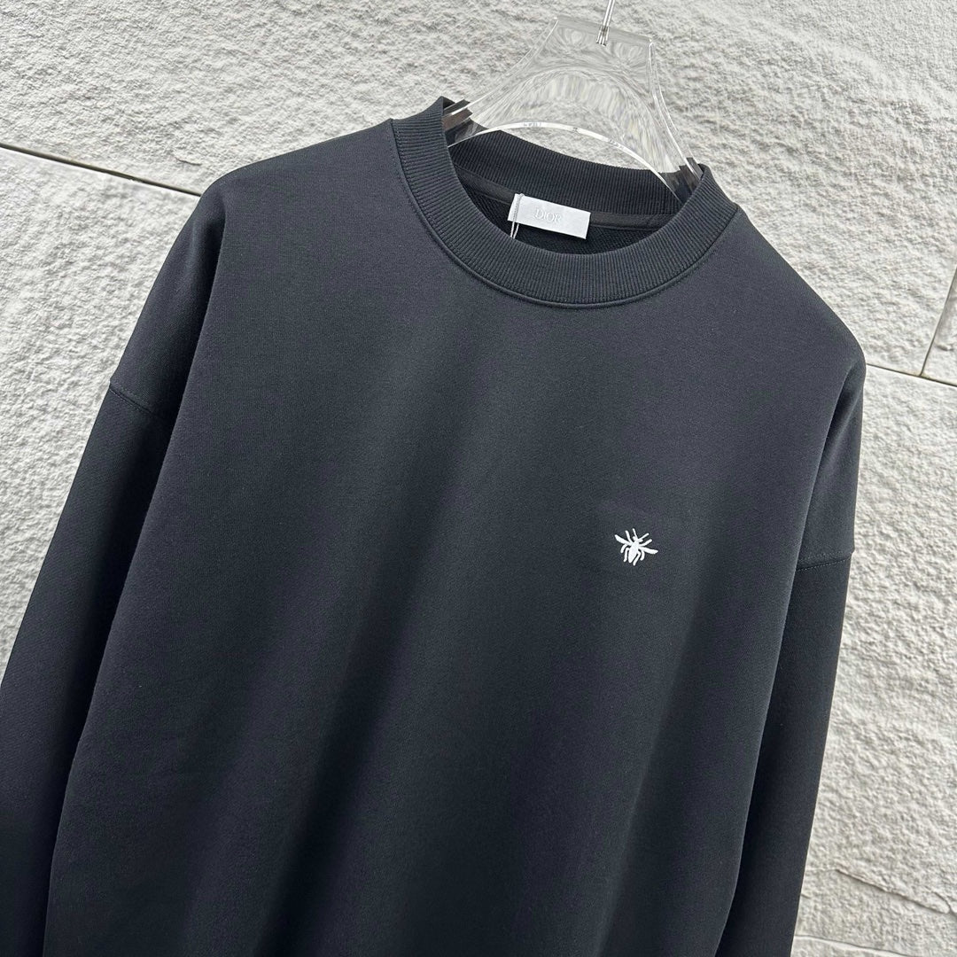 Black crewneck sweatshirt with small white logo on chest