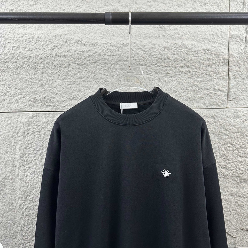 Black crewneck sweatshirt with small white logo on chest