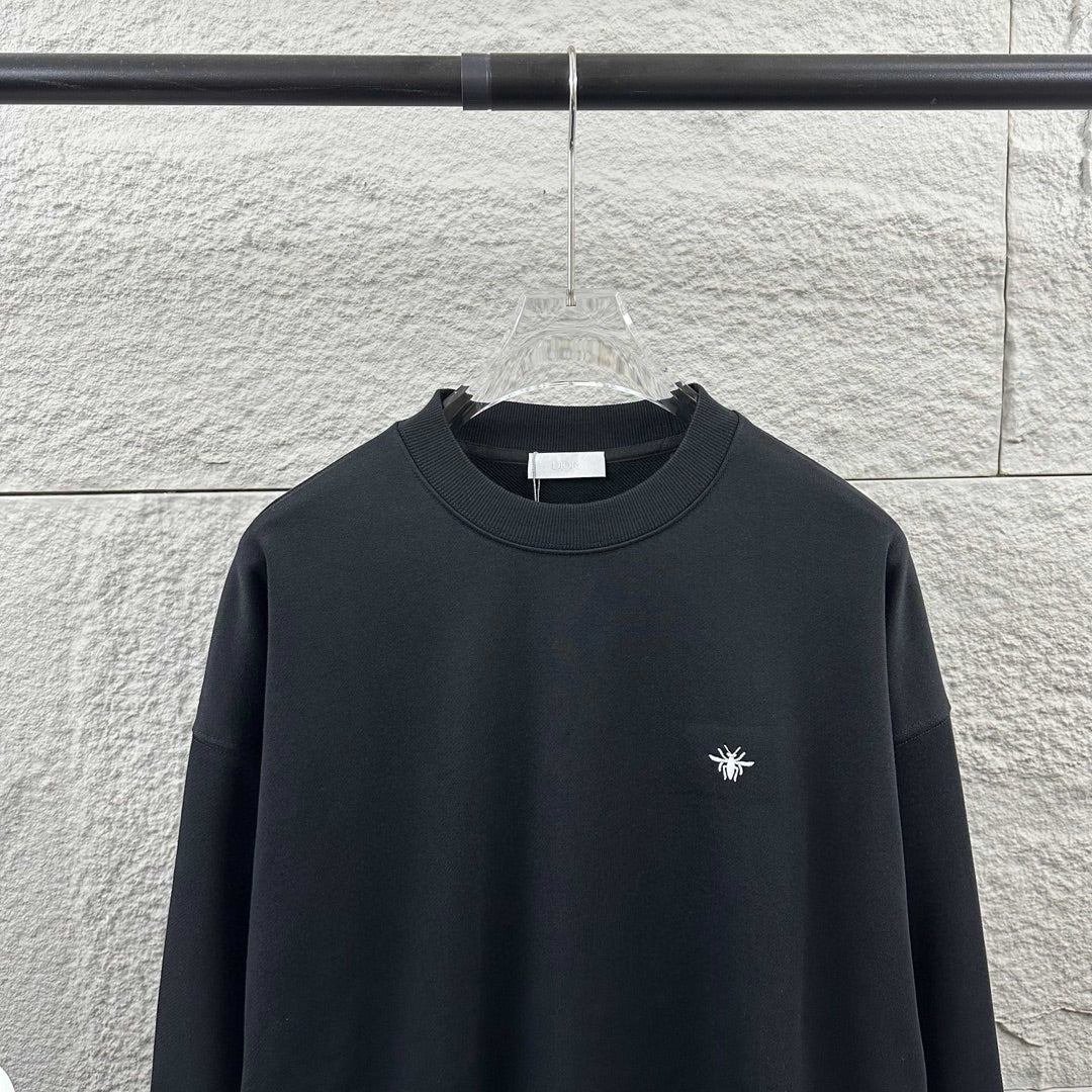 Black crewneck sweatshirt with small white logo on chest