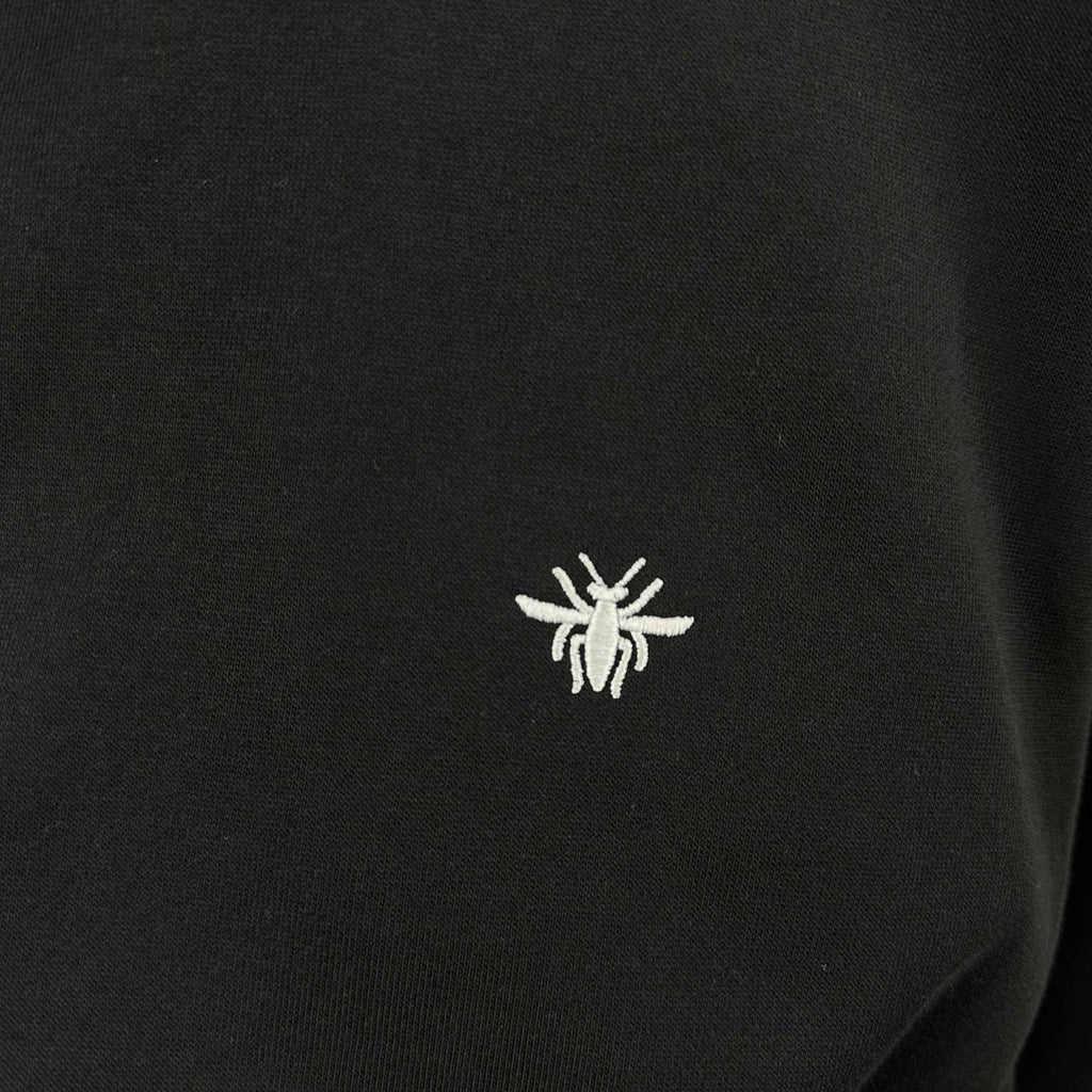 Small white logo on black crewneck sweatshirt