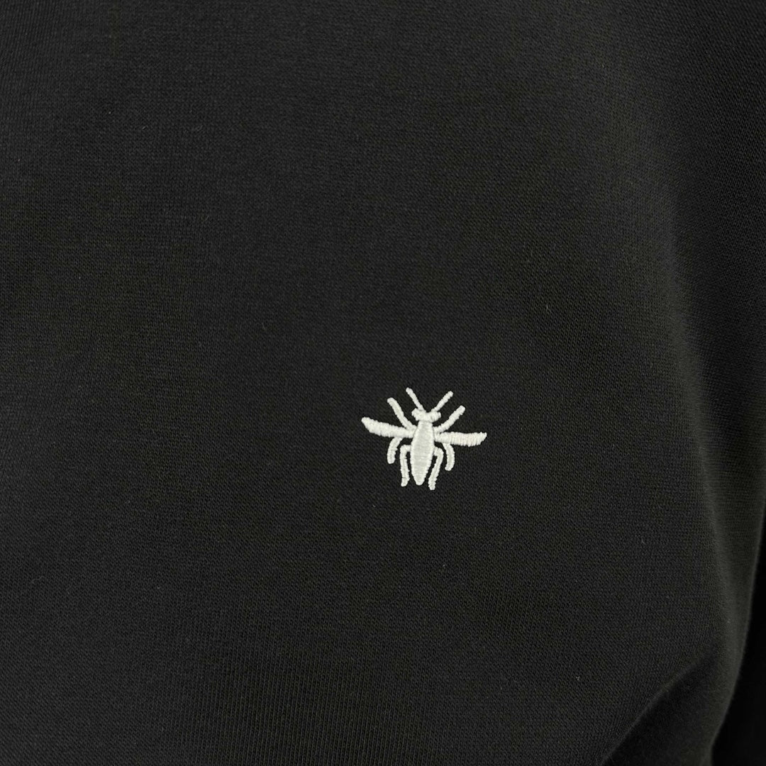 Small white logo on black crewneck sweatshirt