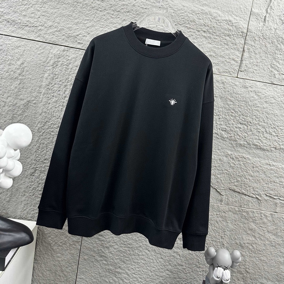 Black crewneck sweatshirt with small white logo, long sleeves and ribbed hem