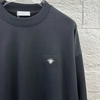 Black sweatshirt with crew neck and small white logo detail on chest