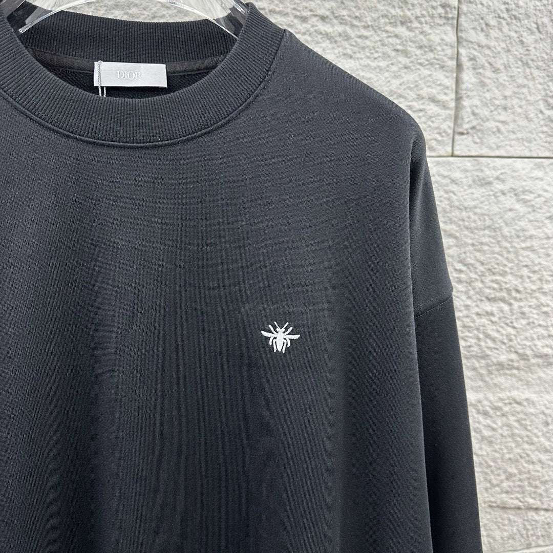 Black sweatshirt with crew neck and small white logo detail on chest