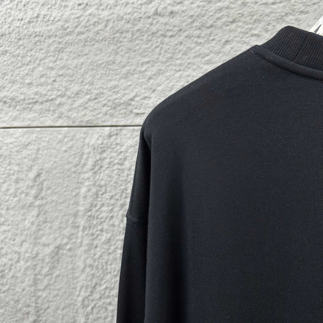 Black sweatshirt fabric close-up near shoulder and collar