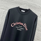 Black sweatshirt close-up with Christian Dior logo text across the chest