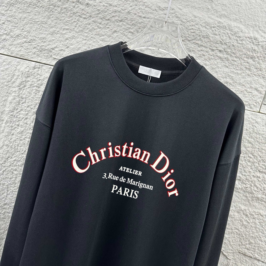 Black sweatshirt close-up with Christian Dior logo text across the chest