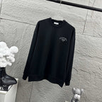 Dark long-sleeve sweatshirt with Christian Dior Atelier chest logo, angled view