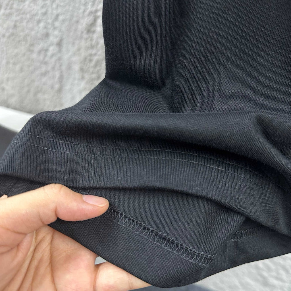 Black T-shirt fabric with stitched hem and sleeve seam detail
