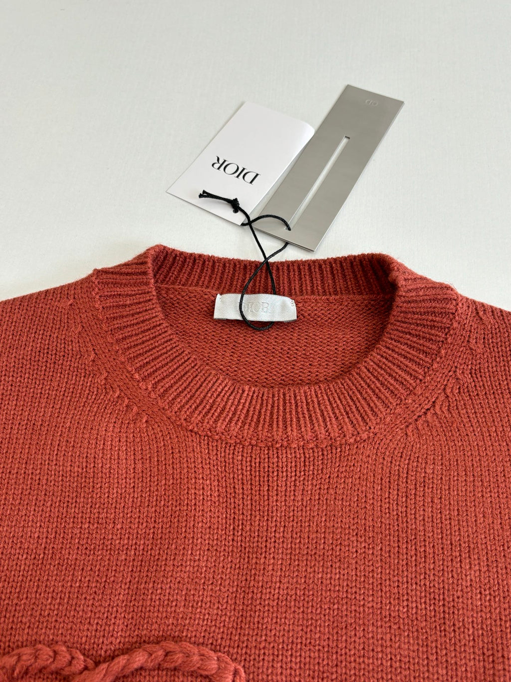 Dior knit sweater neckline, rust red ribbed crew neck with hanging tag