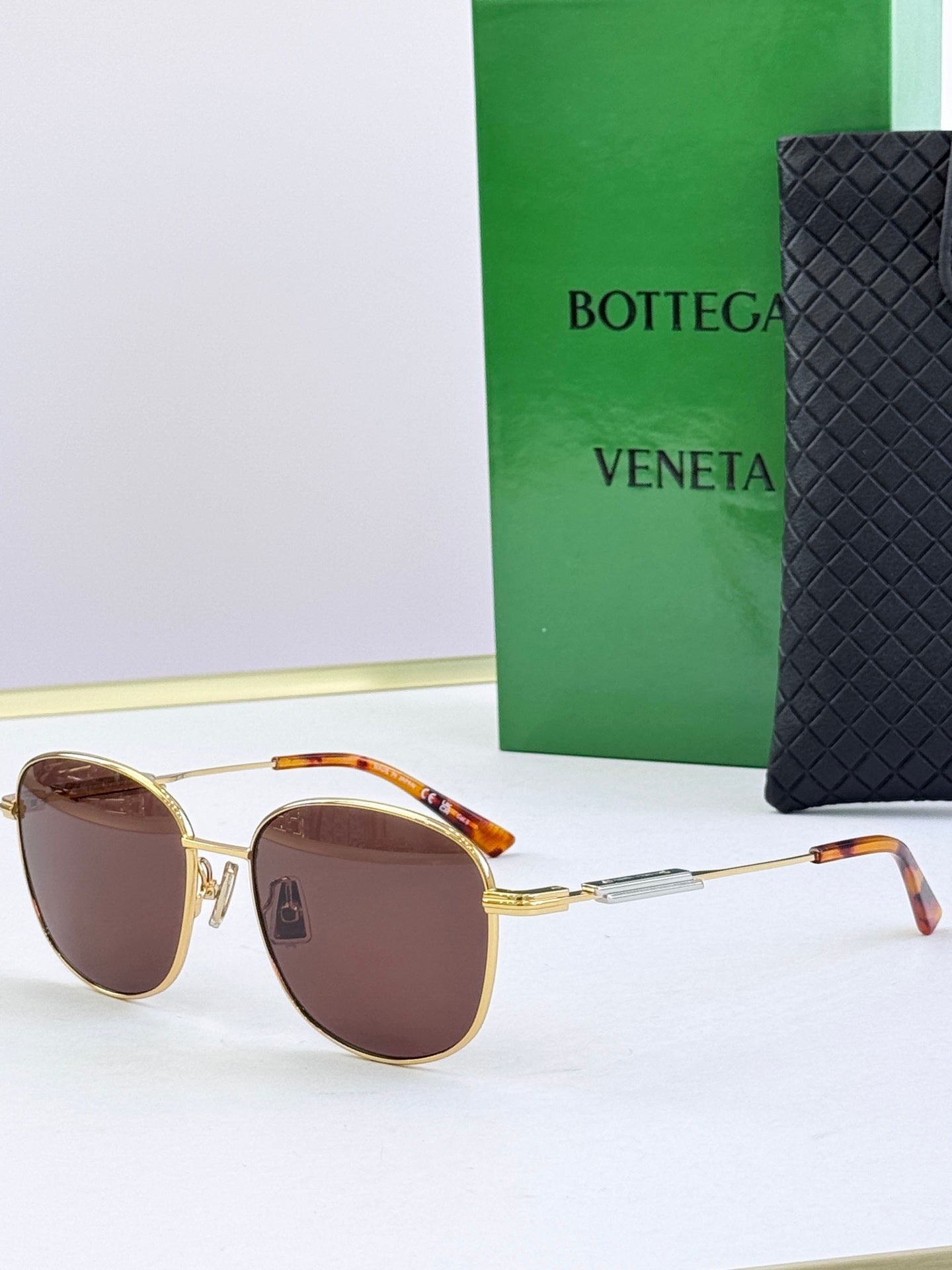 Round sunglasses with brown tinted lenses and gold metal frames