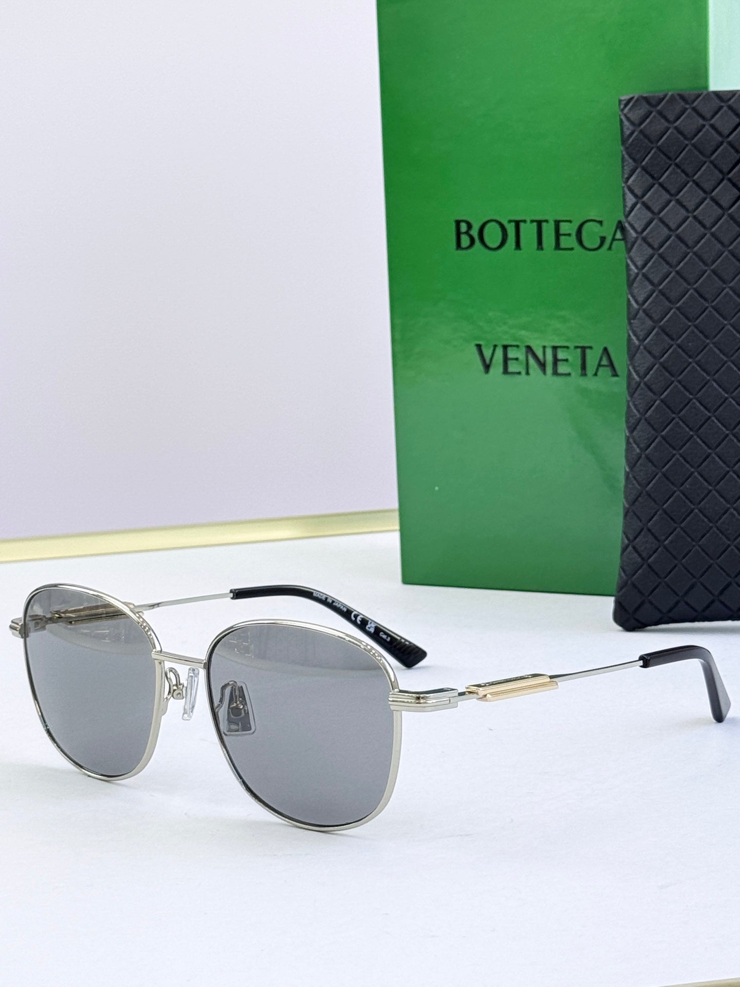 Round sunglasses with gray tinted lenses and silver metal frames