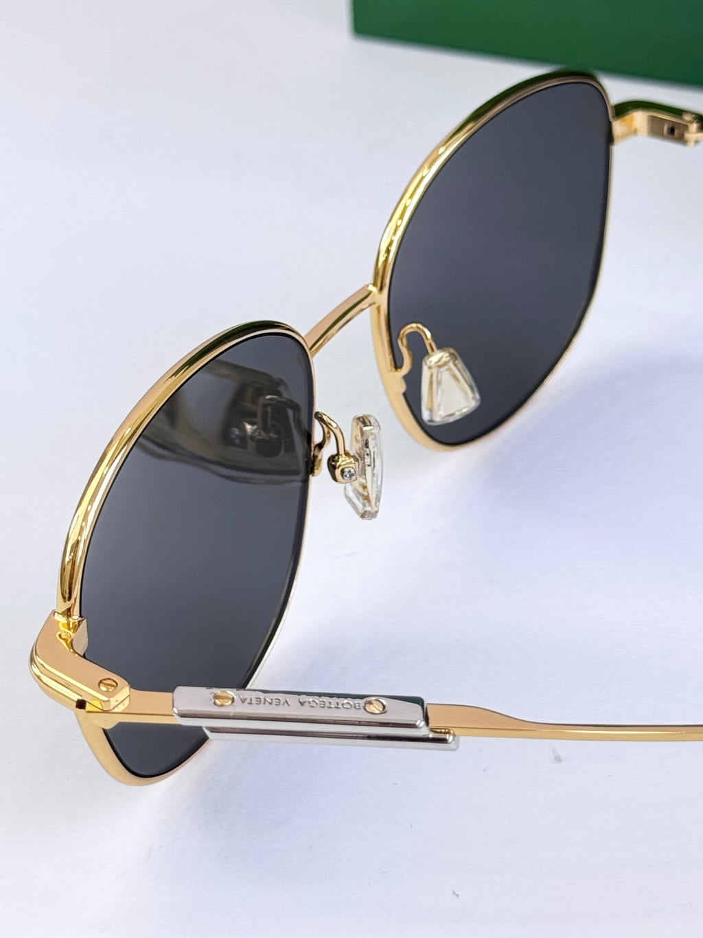 Two round sunglasses with dark lenses and gold metal frames