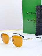 Round sunglasses with amber tinted lenses and silver metal frames