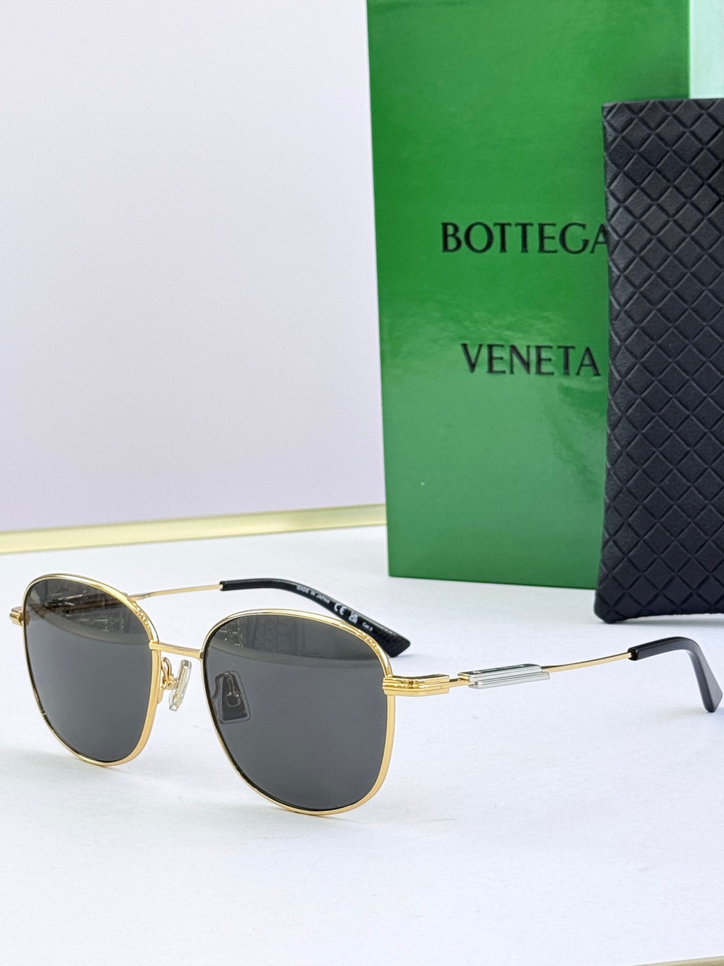 Round sunglasses with dark gray lenses and gold metal frames