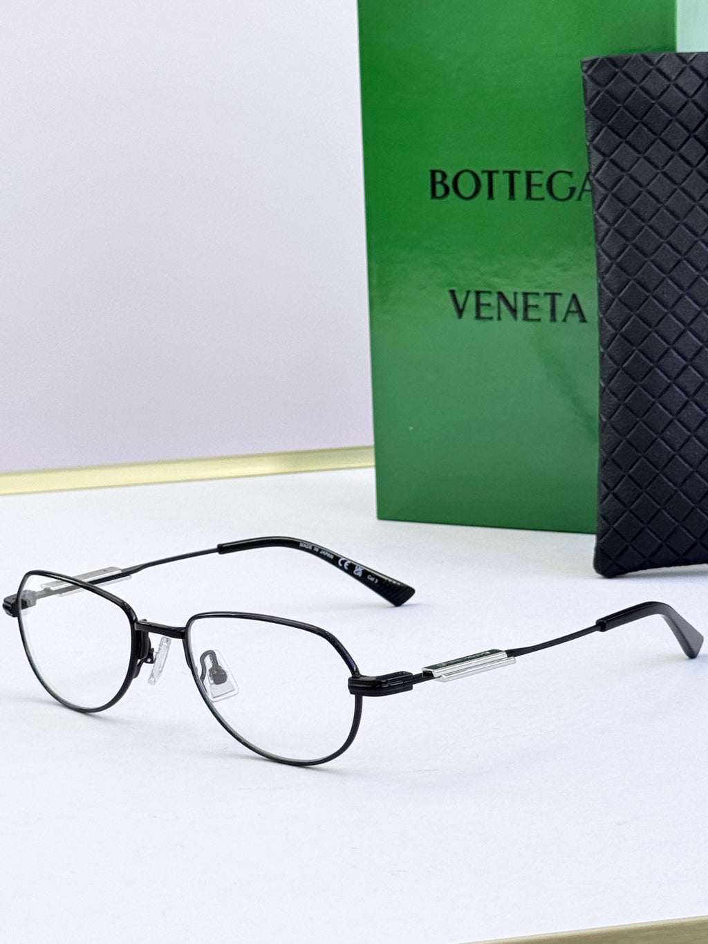 Bottega Veneta glasses with clear lenses and dark frames, side angle