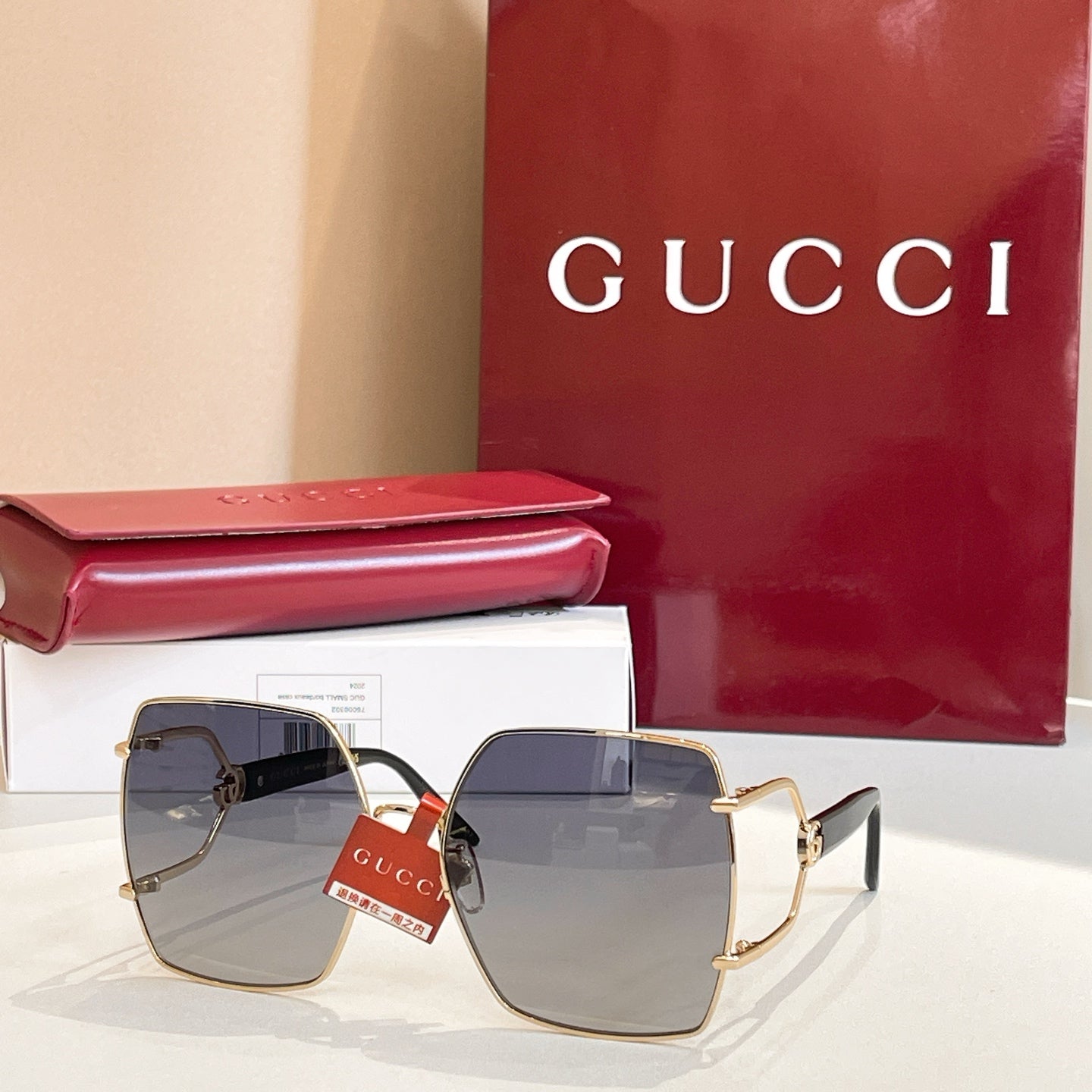 Gucci sunglasses with square gradient lenses and gold-tone frames, blue-gray tones