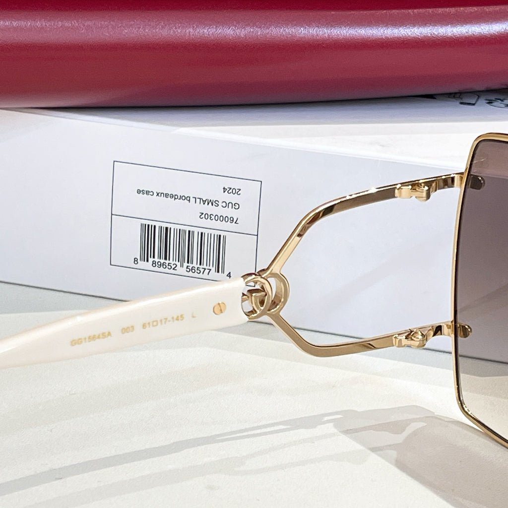 Gucci sunglasses close-up: gold-tone frame with side G emblem and lens corner