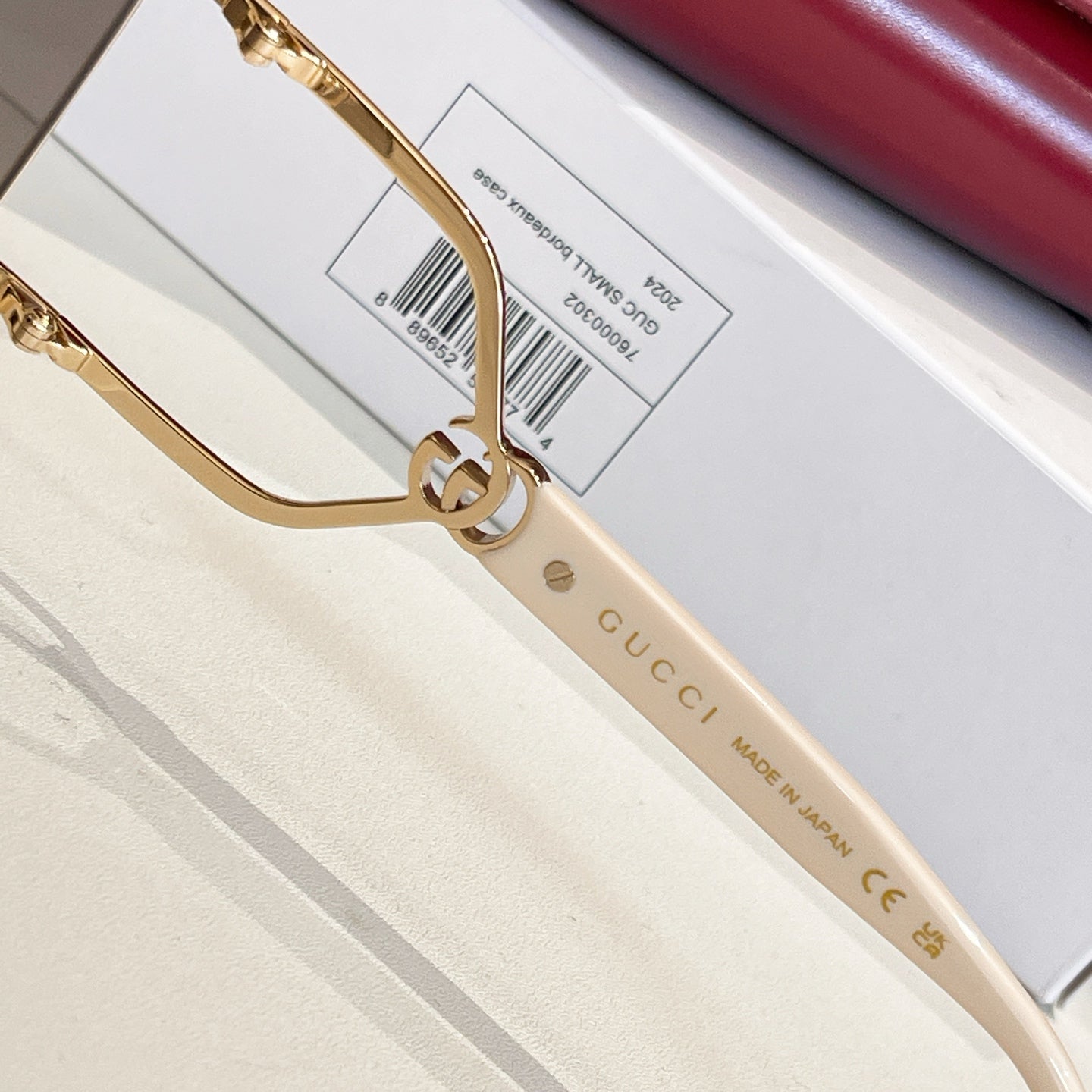 Gucci sunglasses close-up: gold frame and white temple with Gucci text