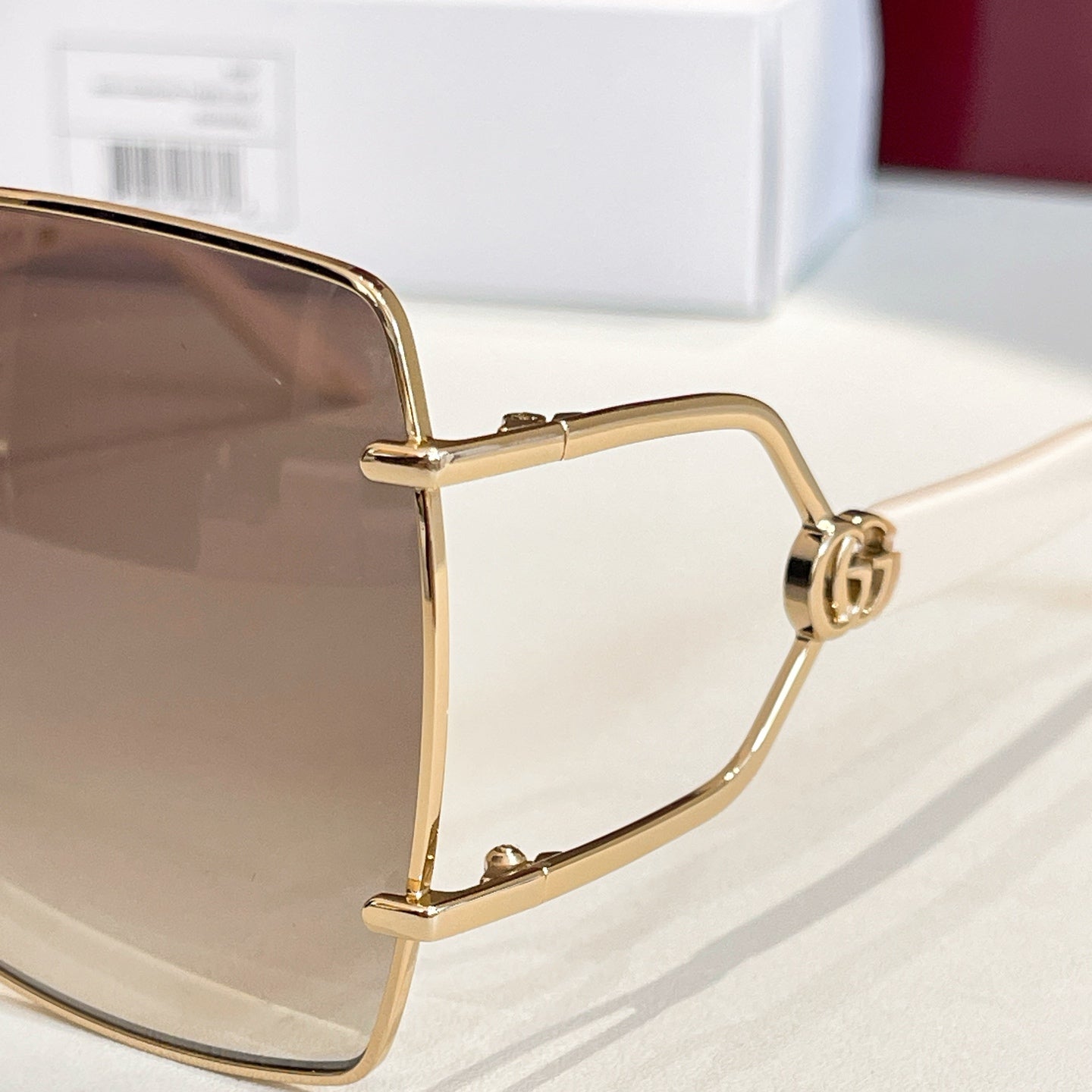 Gucci sunglasses close-up: gold-tone square frame with hinge and side detailing