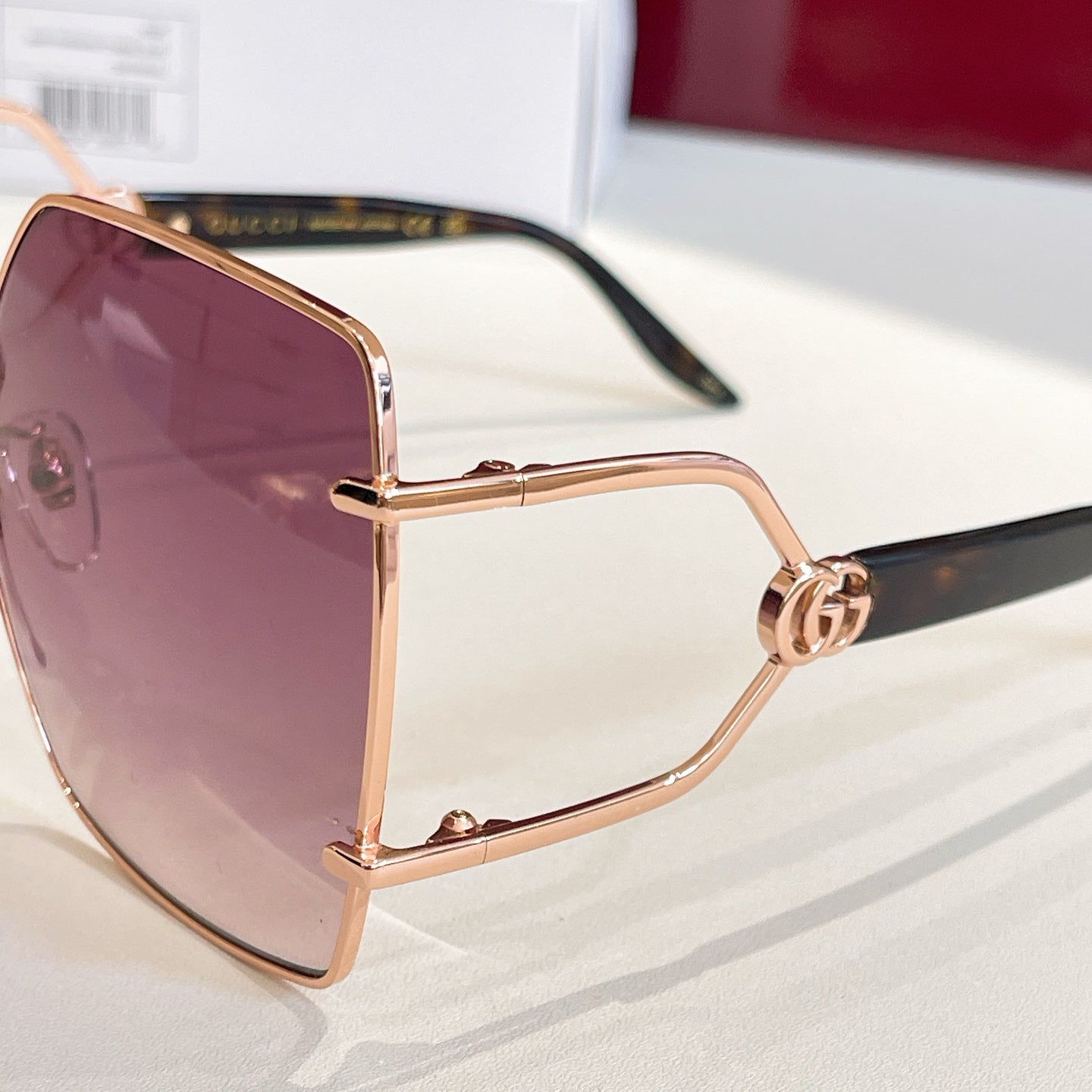 Rose-gold sunglasses with purple tinted lens and slim black temple, side view.