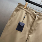 Louis Vuitton tan pants close-up at waistband with button and hanging tag