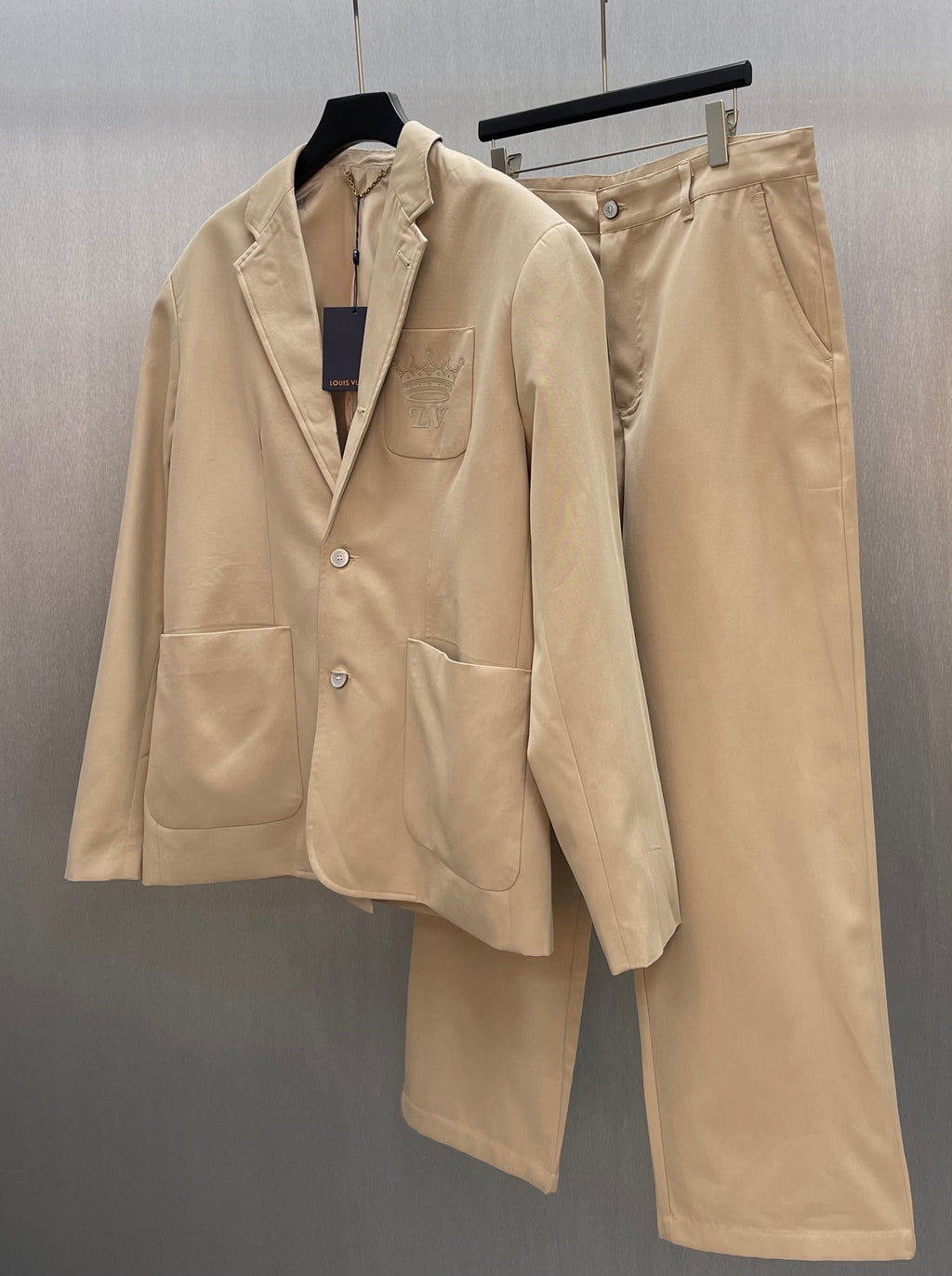 Louis Vuitton tan pants on hanger, front crease and belt loops visible