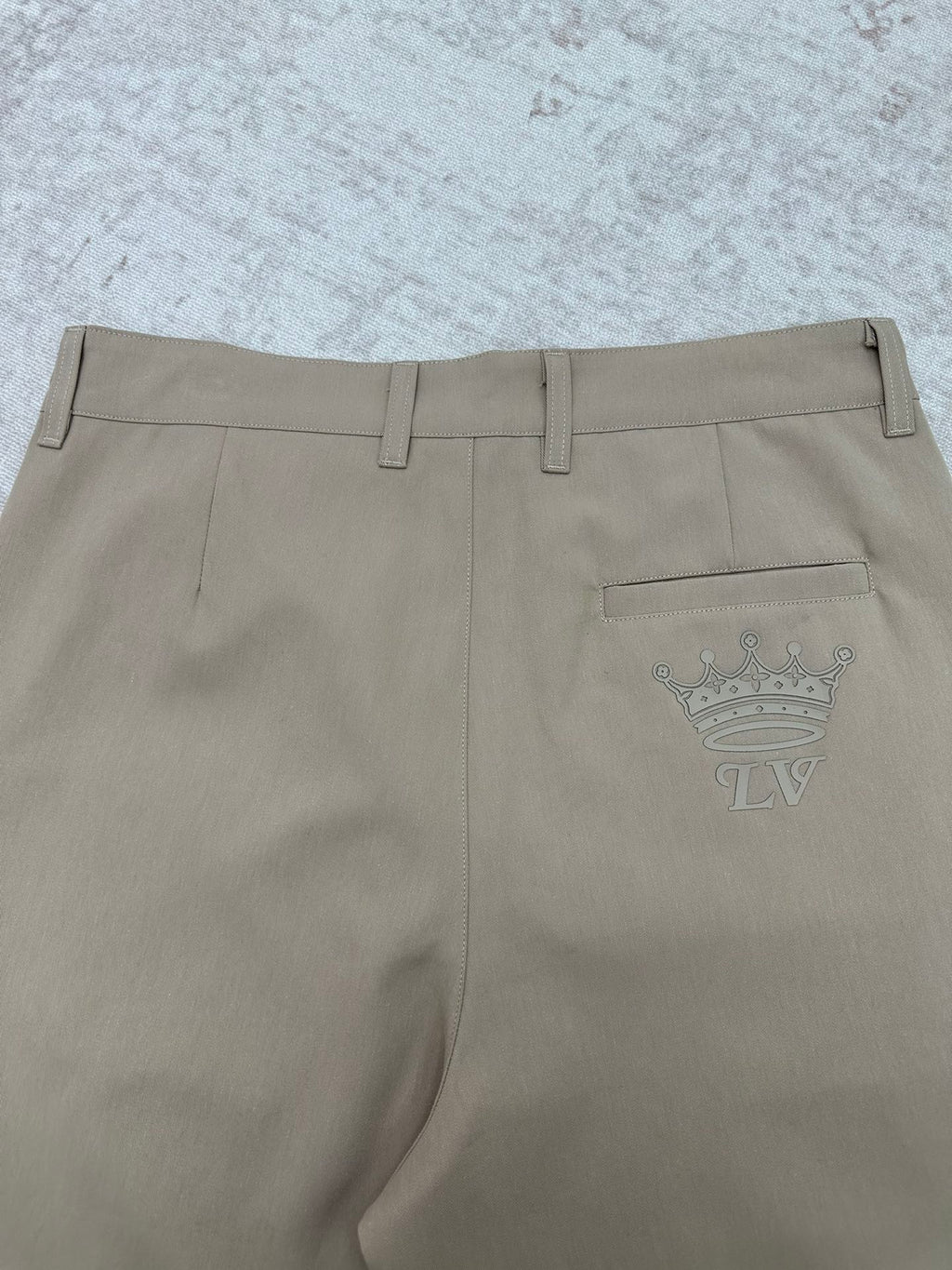 Louis Vuitton pants back view with crown emblem on pocket, light beige
