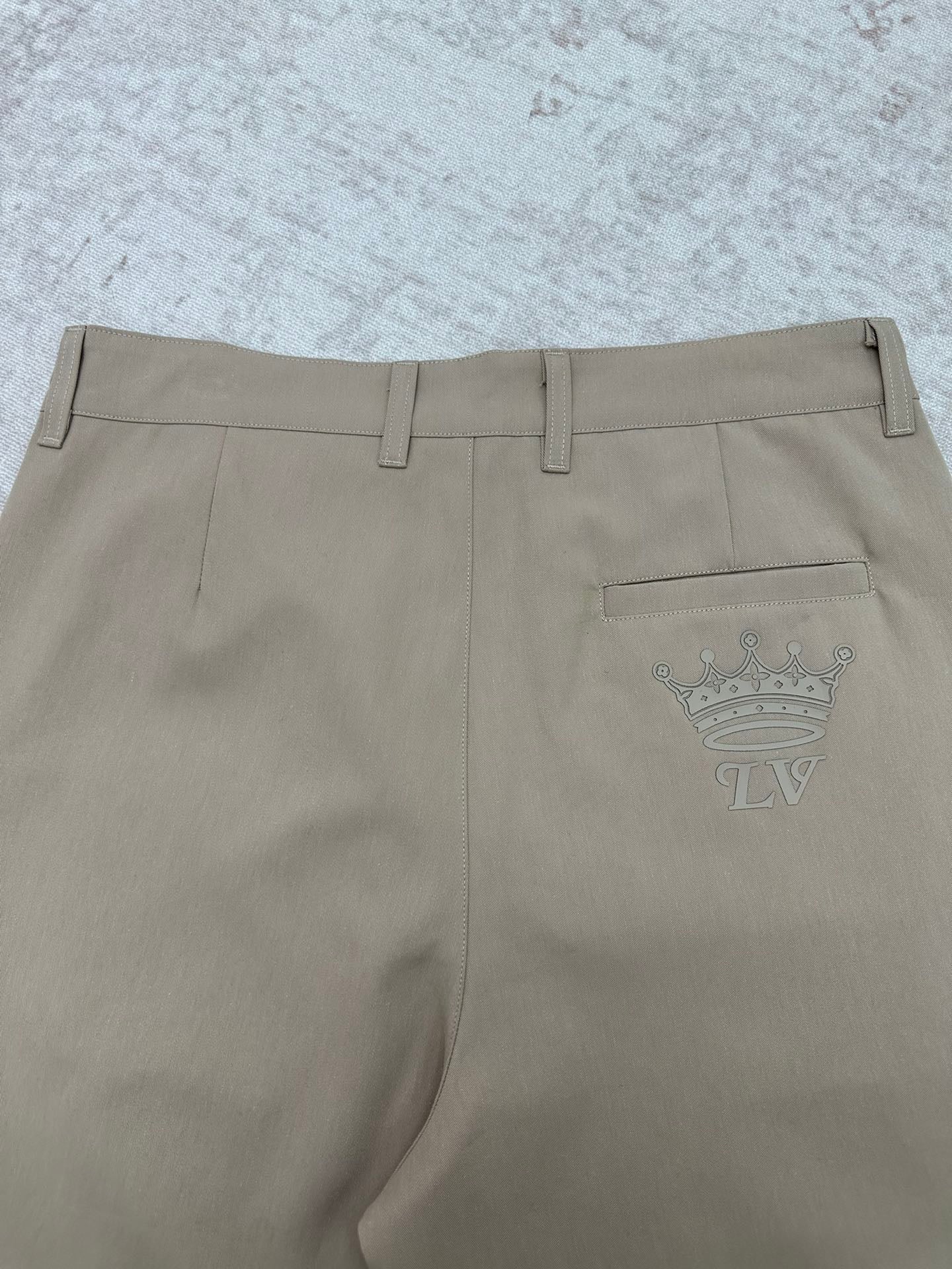 Louis Vuitton pants back view with crown emblem on pocket, light beige