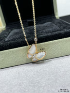 Gold butterfly pendant necklace with pale blue enamel petals on a chain