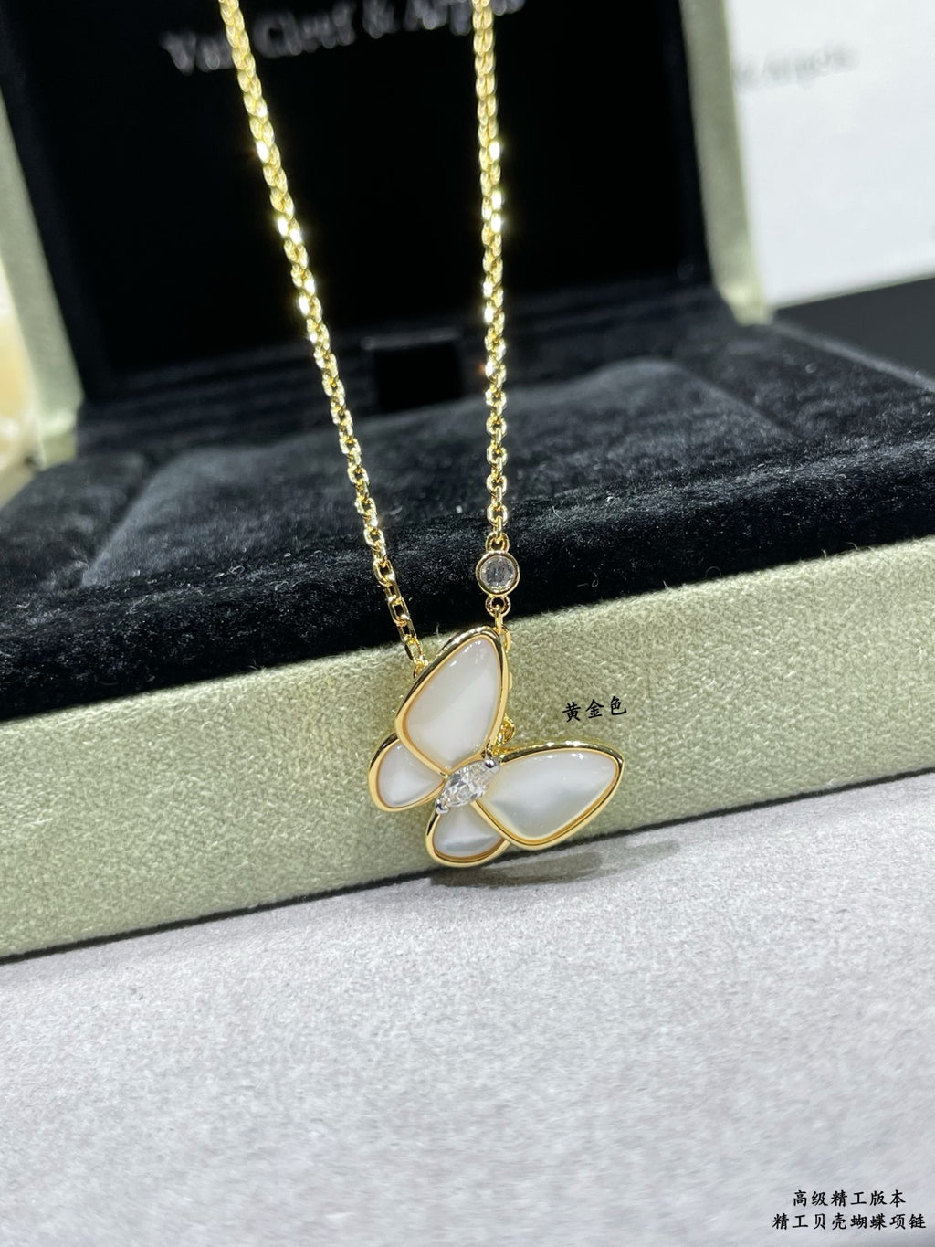 Gold butterfly pendant necklace with pale blue enamel petals and a fine chain
