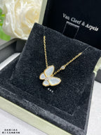Gold butterfly pendant necklace with pale blue enamel and a fine chain