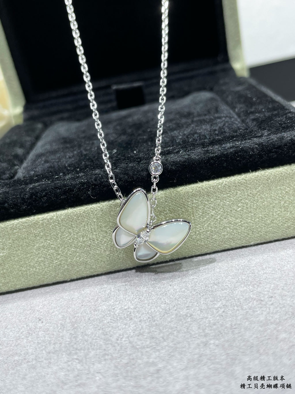 Silver butterfly pendant necklace with pale blue enamel petals on a chain