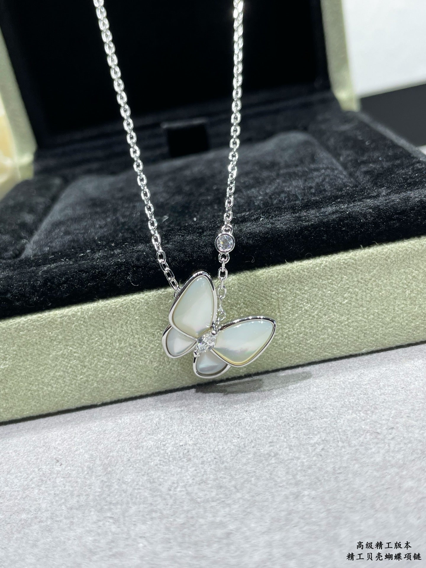 Silver butterfly pendant necklace with pale blue enamel petals on a chain