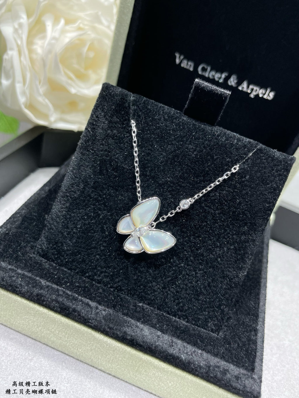 Gold butterfly pendant necklace with light blue enamel petals on a chain