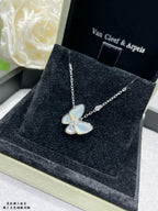 Gold butterfly pendant necklace with light blue enamel petals on a chain